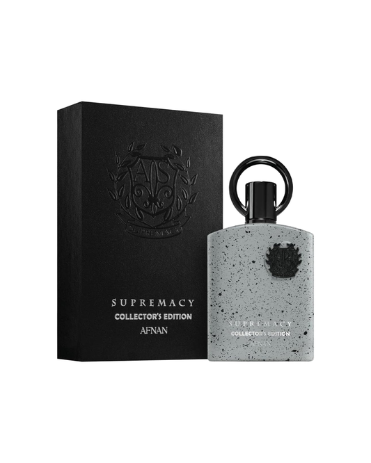 Flacone di profumo Afnan Supremacy Collector's Edition Eau de Parfum 100ml su base in pietra naturale con illuminazione soft-box e vegetazione sfocata.